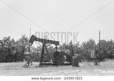 Vintage Tone Working Pump Jack Pumping Crude Oil At Oil Drilling Site In Rural Usa