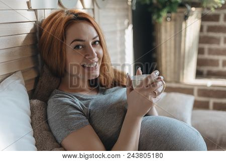 Pregnancy, Drinks, Rest, People And Expectation Concept - Happy Pregnant Woman With Cup Drinking Tea