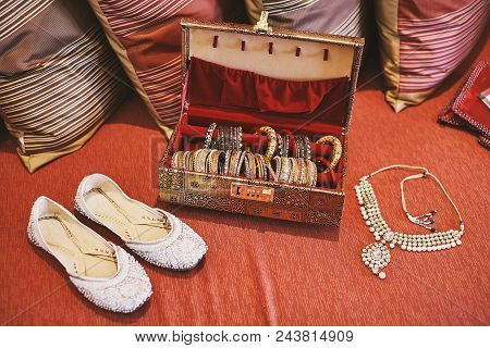A Collection Of Bangles Or Bracelets In The Red Box And White Pump Shoes And Necklace Of Indian Brid