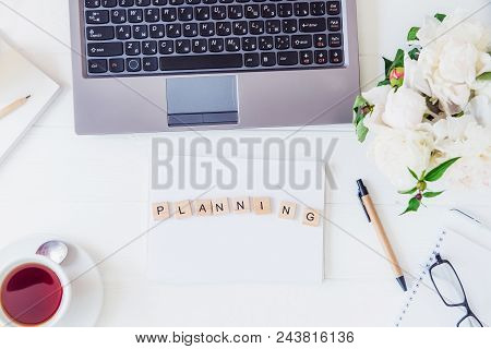 Top View Light Working Place With Laptop Keyboard, Notebook With Plenning Lettering, Cup Of Tea, Sle