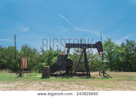 Working Pump Jack Pumping Crude Oil At Oil Drilling Site In Rural Usa