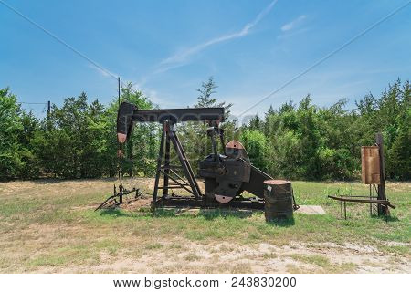 Working Pump Jack Pumping Crude Oil At Oil Drilling Site In Rural Usa