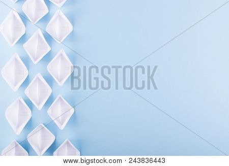 White Paper Boats Or Paper Ships Origami On Blue Background Top View With Place For Text