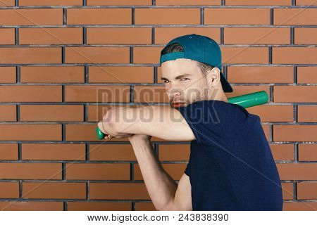 Baseball Bat. Guy In Dark Blue Tshirt Holds Bright Green Bat Ready To Hit. Man In Green Cap On Red B