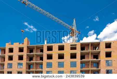 Construction Crane Over A Building Under Construction. Construction Site Background.