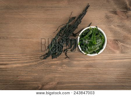 Heap Of Dry Wakame Seaweed On Wooden Background. Healthy Algae Food With Place For Text