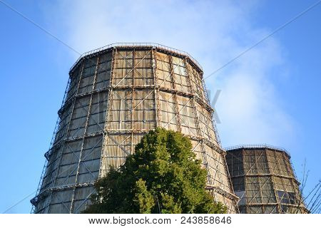 Two Cooling Pipes With A Smoke On A Sunny Day With Clear Blue Sky In Summer