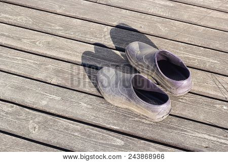 Pair Rubber Galoshes Stand On Wooden Boards