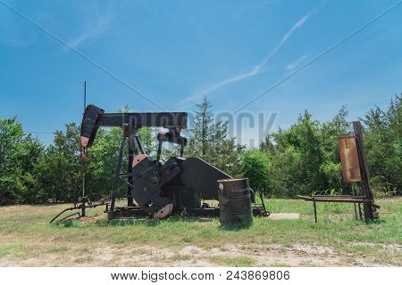 Working Pump Jack Pumping Crude Oil At Oil Drilling Site In Rural Usa