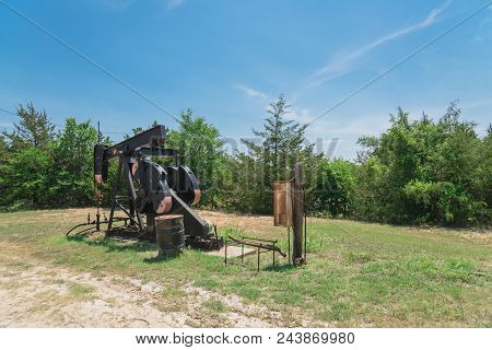 Working Pump Jack Pumping Crude Oil At Oil Drilling Site In Rural Usa