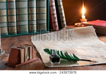 Green Quil Pen And Black Inkwell With Old Papers And Books