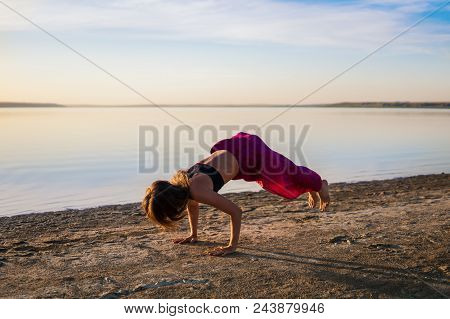 Silhouette Woman On The Beach At Sunset Doing Yoga Asana. Morning Natural Stretch Warm-up Training