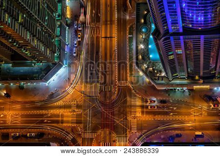 Top view on Dubai skyline during night with amazing city center crossroad lights and road traffic,United Arab Emirates.