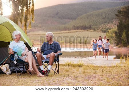 Multi Generation Family On Camping Trip By Lake Together