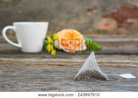 Tea Bag On Background Of Rose And And Cup Of Tea.