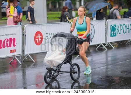 Dnipro, Ukraine - May 20, 2017: Young Woman Running With Baby Carriage  During Of The Interipe  Dnip