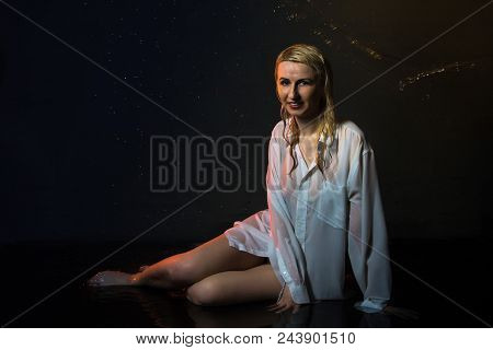 Nice Girl In The White Shirt And Water Drops Behind And Arround Her Illuminated By Light During A Ph