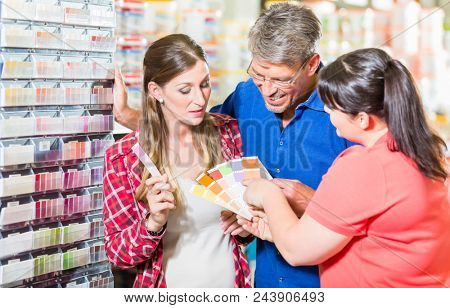Home improvement store clerk counseling customers about choice of colour for wall paint