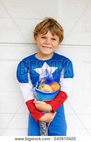 Happy Little Kid Boy In Superhero Costume On His First Day To School . Child Outdoors On Warm Sunny 