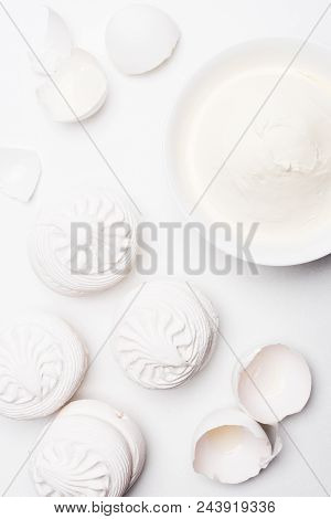 Top View Of Delicious Zefir With Bowl Of Sour Cream And Cracked Egg Shells On White Surface