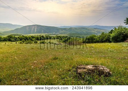 Green Meadow On The Background With Distant Mountains. Open Field With Green Grass. Landscape Photog