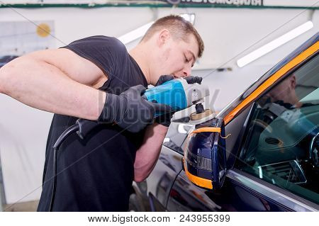A Man Is Polishing A Blue Car. Polishing Machine And Polishing Paste For Gloss.