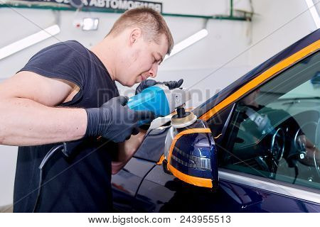 A Man Is Polishing A Blue Car. Polishing Machine And Polishing Paste For Gloss.