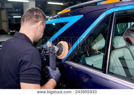 A Man Is Polishing A Blue Car. Polishing Machine And Polishing Paste For Gloss.