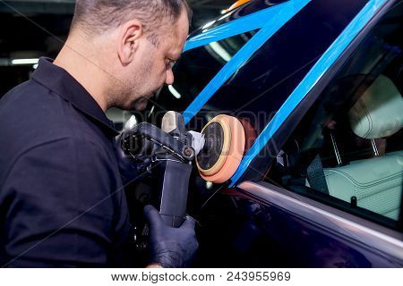 A Man Is Polishing A Blue Car. Polishing Machine And Polishing Paste For Gloss.