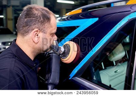A Man Is Polishing A Blue Car. Polishing Machine And Polishing Paste For Gloss.