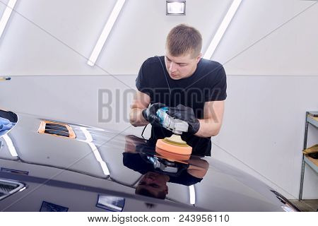 A Man Is Polishing A Blue Car. Polishing Machine And Polishing Paste For Gloss.