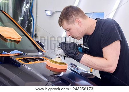 A Man Is Polishing A Blue Car. Polishing Machine And Polishing Paste For Gloss.