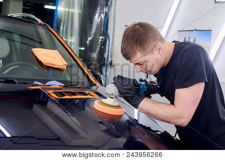 A Man Is Polishing A Blue Car. Polishing Machine And Polishing Paste For Gloss.