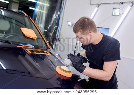 A Man Is Polishing A Blue Car. Polishing Machine And Polishing Paste For Gloss.
