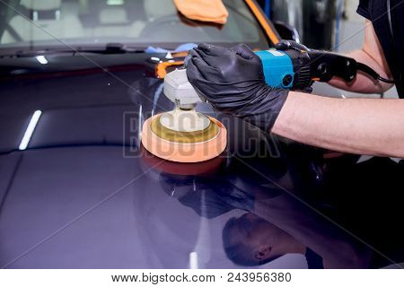 A Man Is Polishing A Blue Car. Polishing Machine And Polishing Paste For Gloss.
