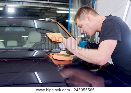A Man Is Polishing A Blue Car. Polishing Machine And Polishing Paste For Gloss.