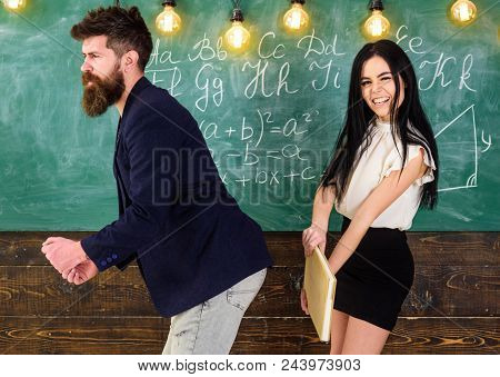 Student Lady Slapping On Teachers Buttocks With Book. Girl On Smiling Face Having Fun While Punishes