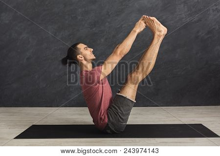 Young Man Practicing Yoga With Gymnastic Mat, Making Corner Stretching Exercise, Copy Space