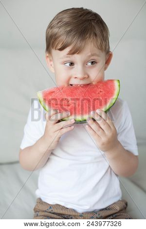 A Small Cute Boy 4 Years Old Is Eating A Watermelon. Summer. Heat. Watermelon. Portrait Of A Happy B