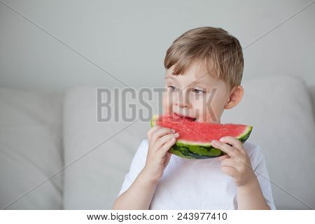 A Small Cute Boy 4 Years Old Is Eating A Watermelon. Summer. Heat. Watermelon. Portrait Of A Happy B