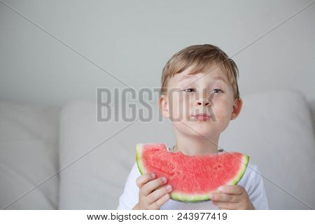 A Small Cute Boy 4 Years Old Is Eating A Watermelon. Summer. Heat. Watermelon. Portrait Of A Happy B