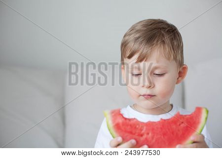A Small Cute Boy 4 Years Old Is Eating A Watermelon. Summer. Heat. Watermelon. Portrait Of A Happy B