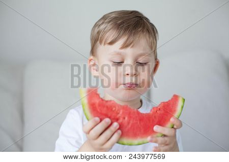 A Small Cute Boy 4 Years Old Is Eating A Watermelon. Summer. Heat. Watermelon. Portrait Of A Happy B