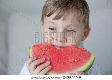 A Small Cute Boy 4 Years Old Is Eating A Watermelon. Summer. Heat. Watermelon. Portrait Of A Happy B