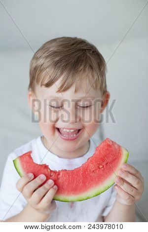 A Small Cute Boy 4 Years Old Is Eating A Watermelon. Summer. Heat. Watermelon. Portrait Of A Happy B
