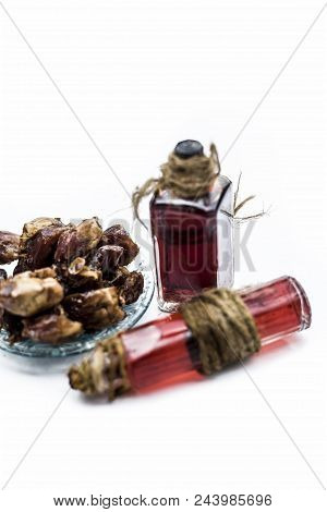 Sweet and floral essence of Date or khajoor in bottles isolated on white used in flavored chocolate 