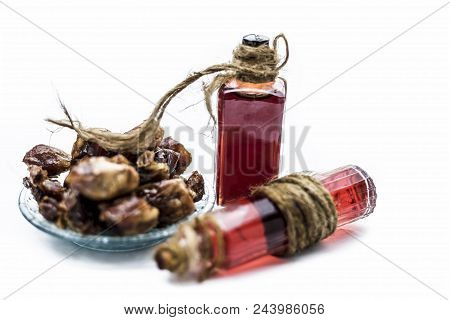 Sweet and floral essence of Date or khajoor in bottles isolated on white used in flavored chocolate 