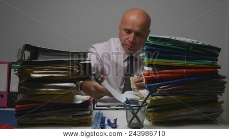 Businessman Eating A Sandwich And Read Financial Documents In Office Room