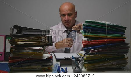 Thirsty Businessman Working And Opening A Bottle With Fresh Water