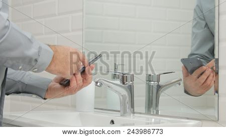 Businessman In Modern Bathroom Use Mobile Phone Accessing Online Urgent Messages